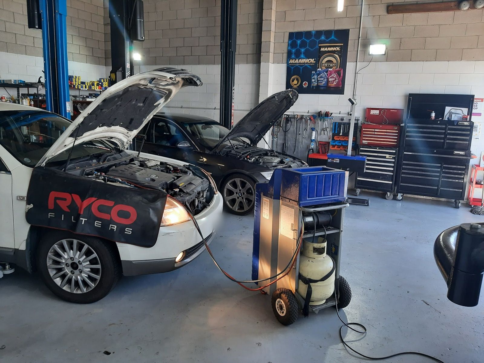 Air-conditioning service machine connected to a car in the workshop